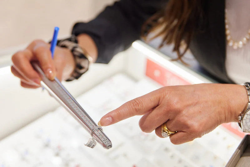 Person holding a pen and pointing at a product in a store