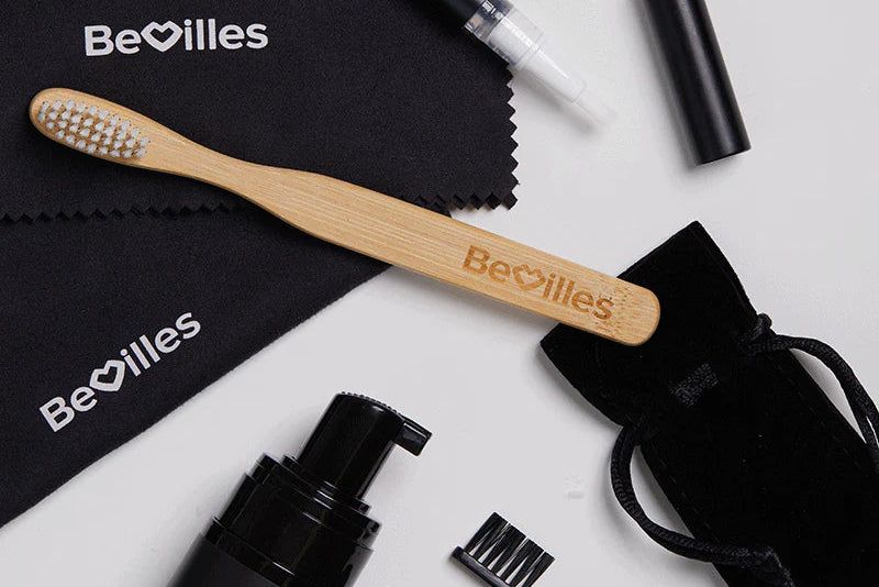 Bevilles skincare and grooming products including a bamboo toothbrush, black bottles, and a pouch on a white background.